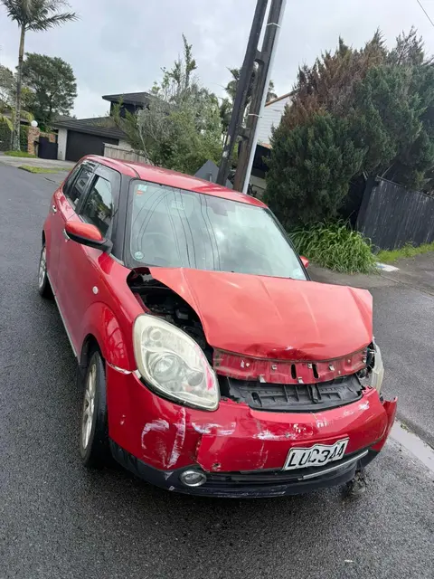 Red Mazda2 with crushed front end